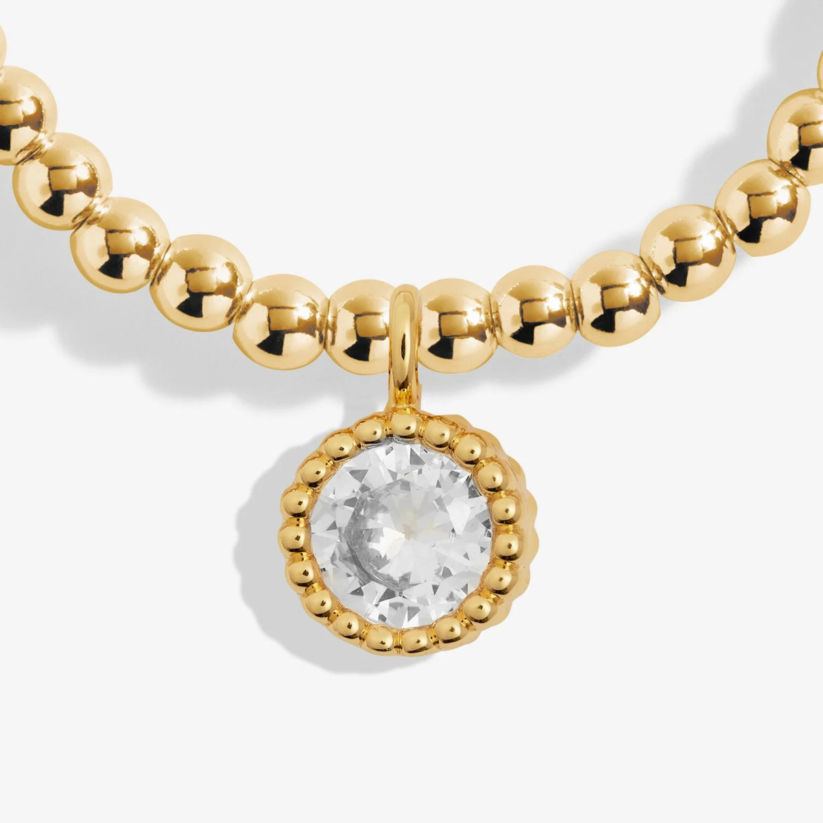 Gold necklace with a round pendant on a white background