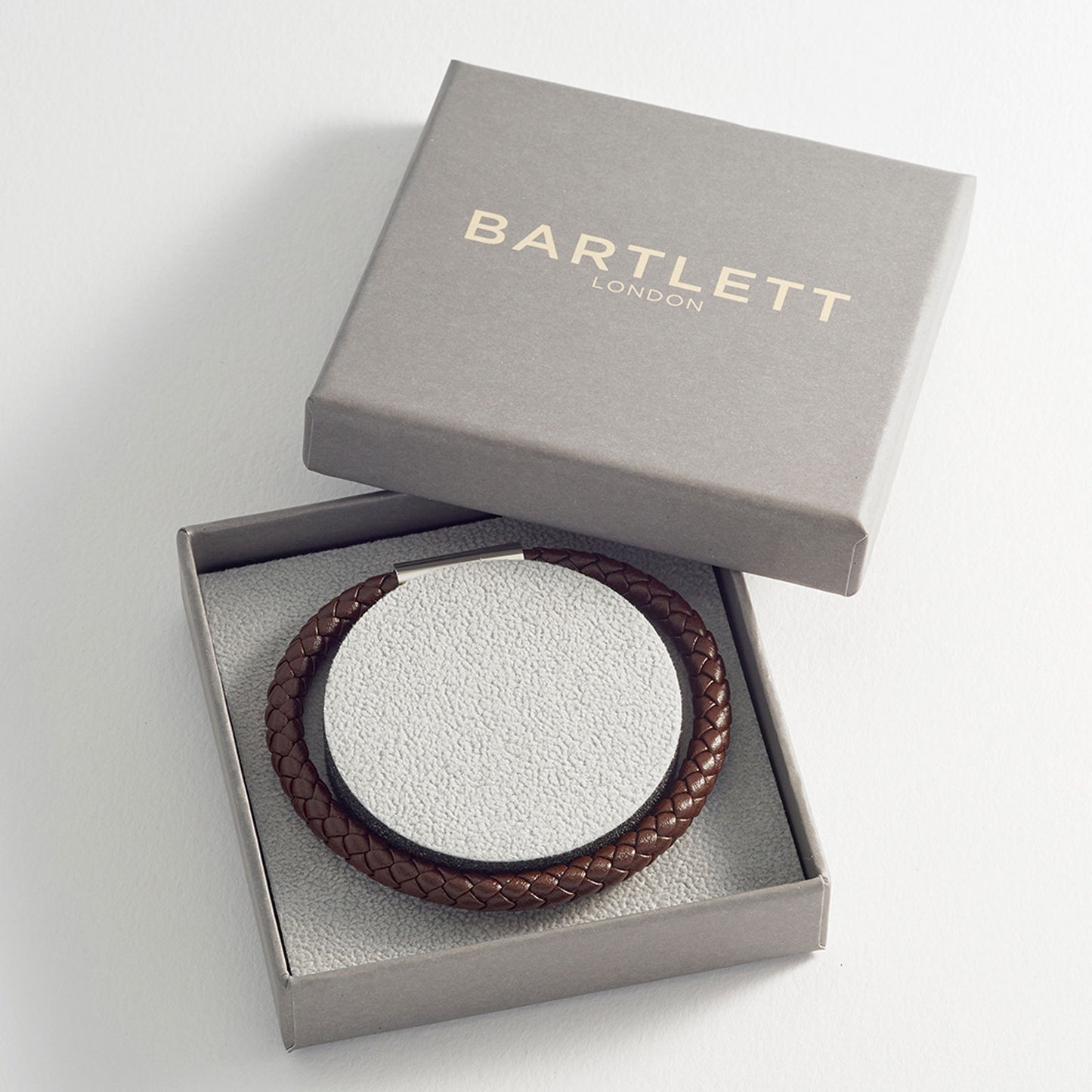 Brown braided bracelet in a 'Bartlett London' box on a light gray background