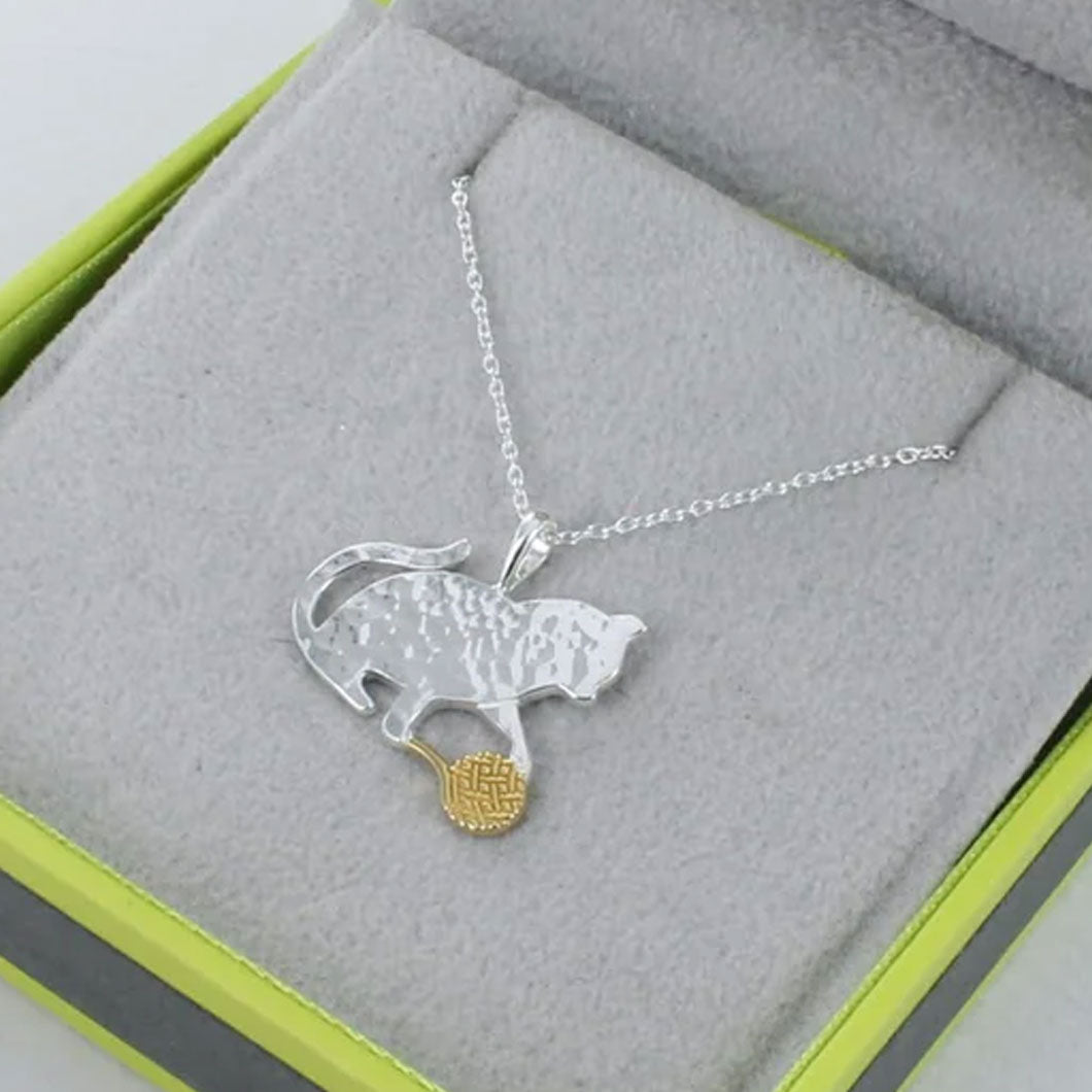 Silver necklace with a panther pendant on a gray surface