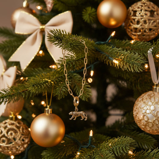 Gold chain bracelet with a tiger charm on a white background