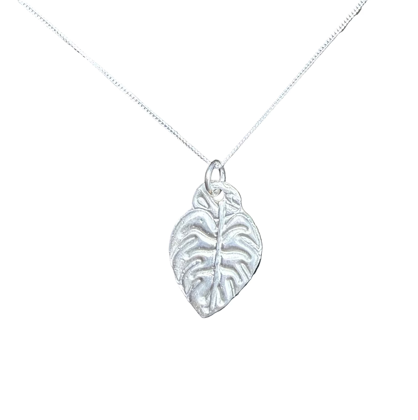 Silver leaf pendant on a chain against a white background