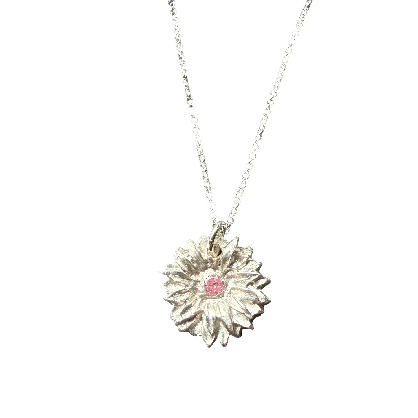 Silver necklace with a sunflower pendant on a stone surface
