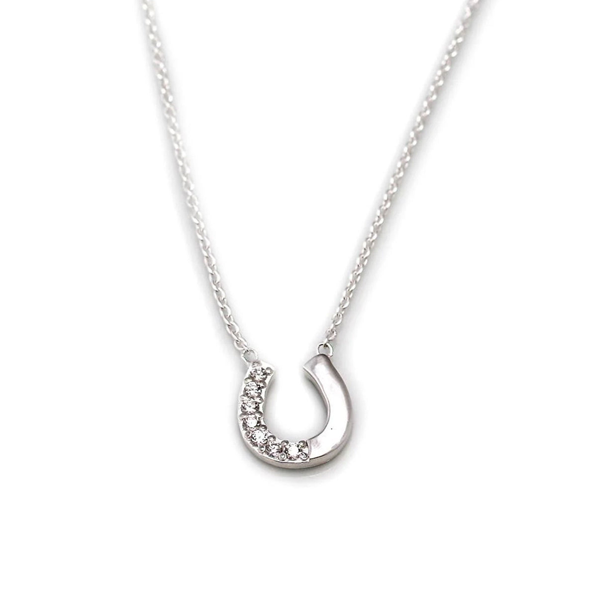 A silver horseshoe pendant necklace adorned with small clear stones along one curved edge, suspended from a delicate silver chain against a plain white background.