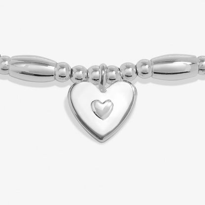 Silver bracelet with a heart-shaped charm on a white background