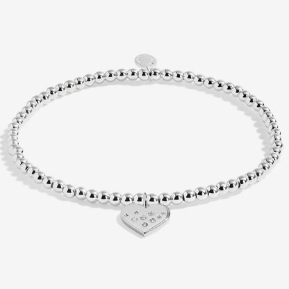 Silver beaded bracelet with a heart-shaped tag on a white background
