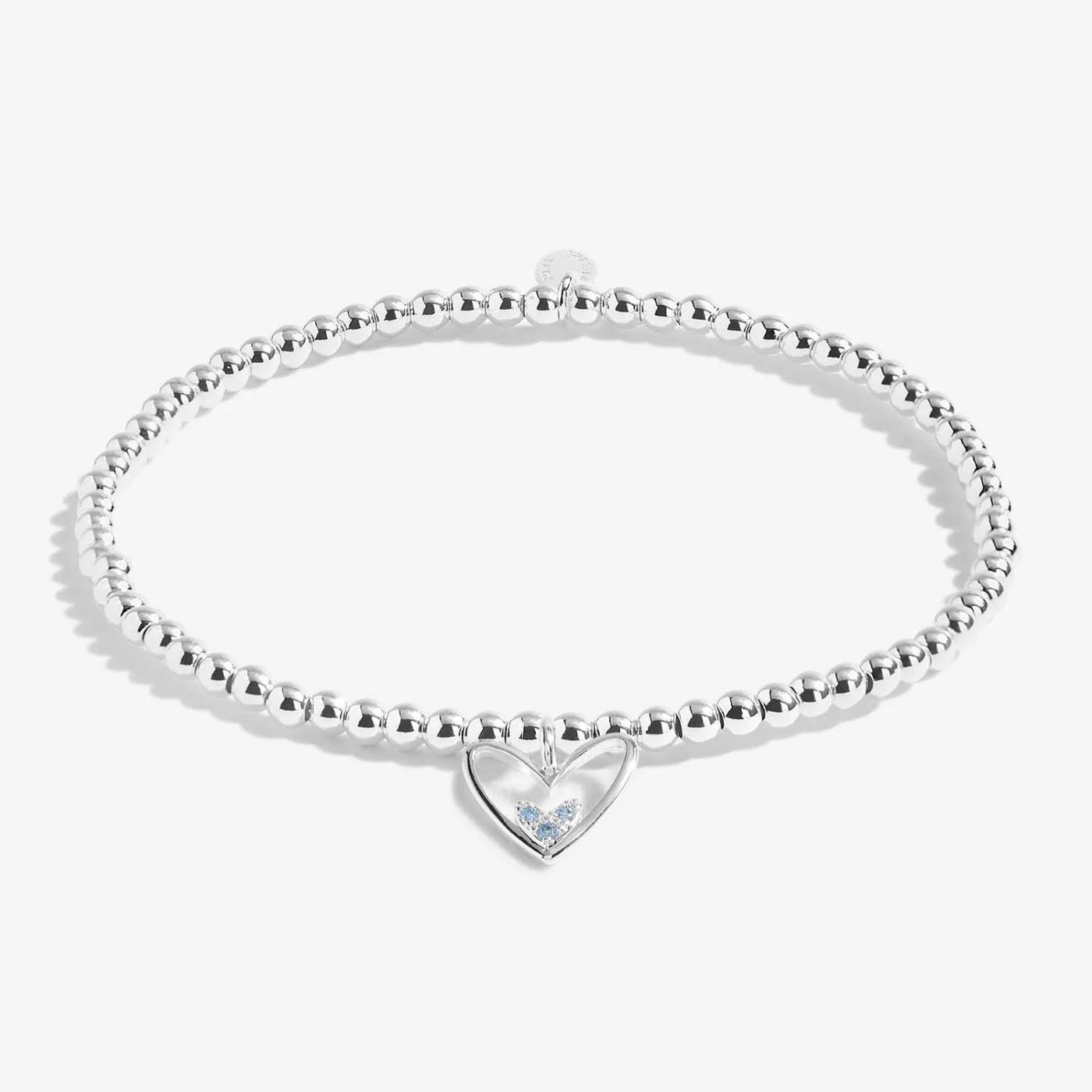 Silver beaded bracelet with a heart-shaped tag on a white background