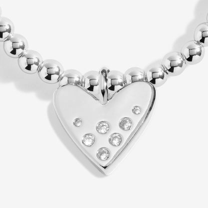 Silver heart-shaped pendant with embedded stones on a white background