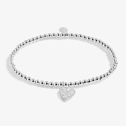 Silver bracelet with a heart-shaped charm on a white background