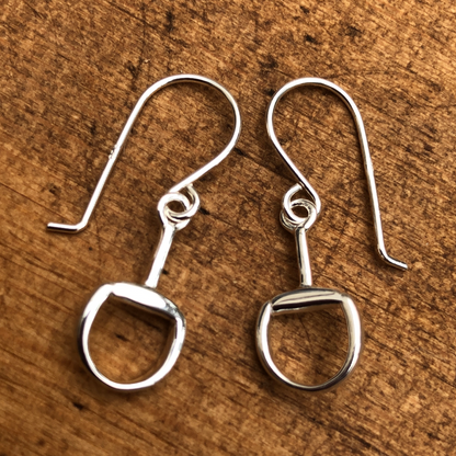 Pair of silver earrings on a wooden surface