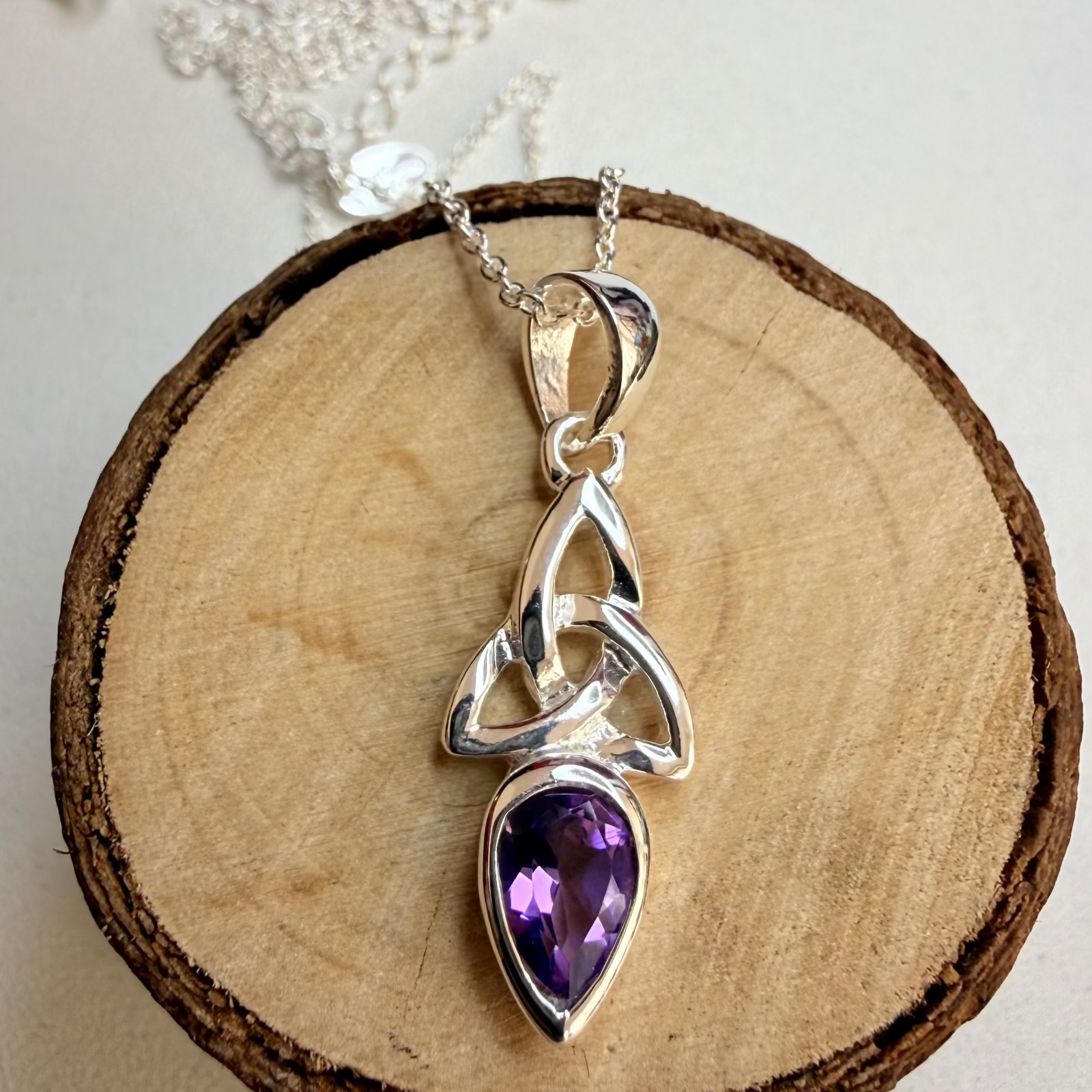 amethyst celtic knot necklace on log