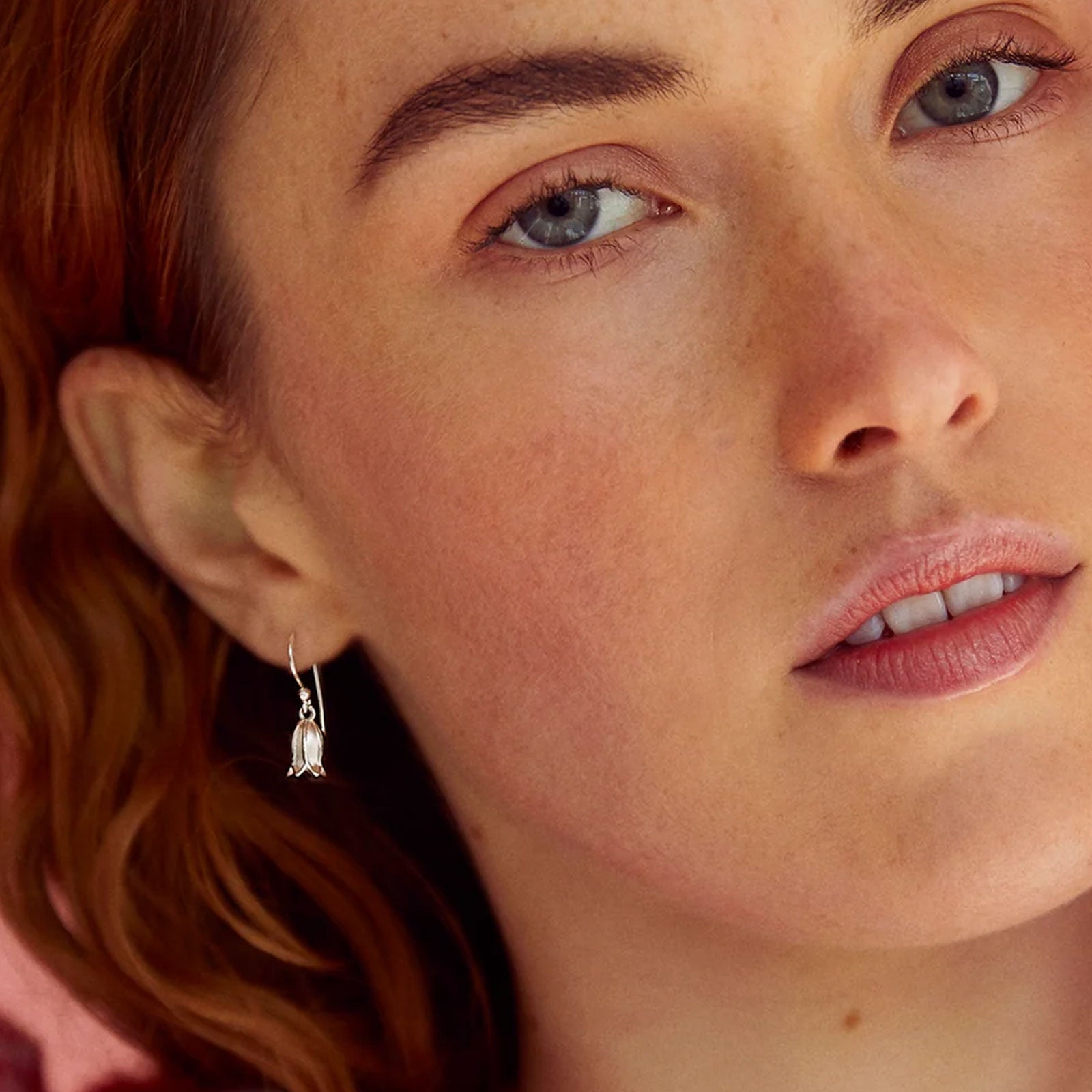 Close-up of a woman's face with a focus on her earrings.