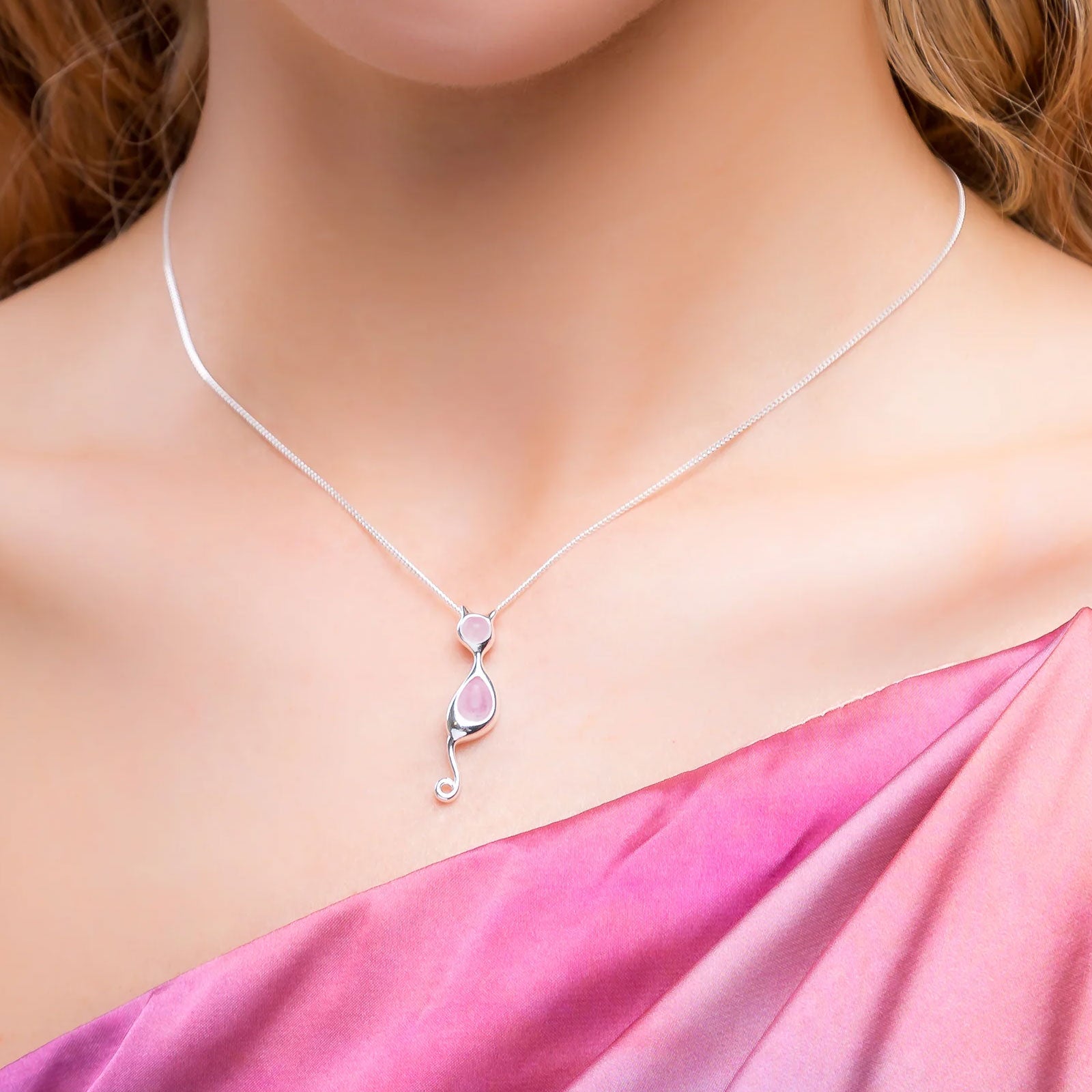 Necklace with a pink pendant on a model wearing a pink dress