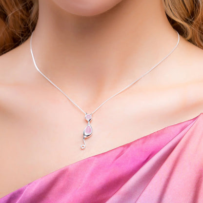 Necklace with a pink pendant on a model wearing a pink dress