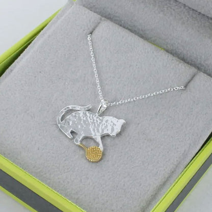 Silver necklace with a panther pendant on a gray surface