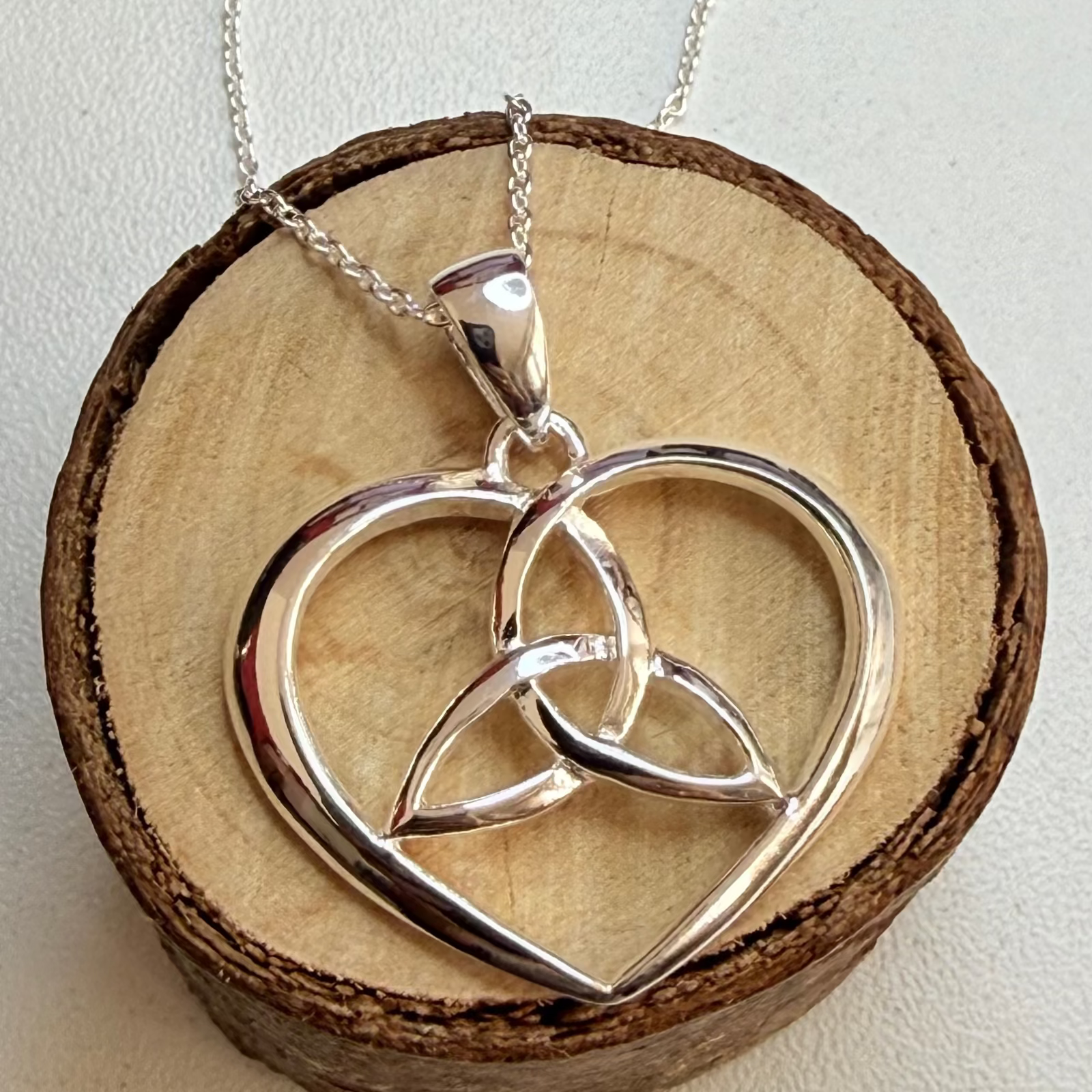 celtic-heart-necklace-on-wooden-circle
