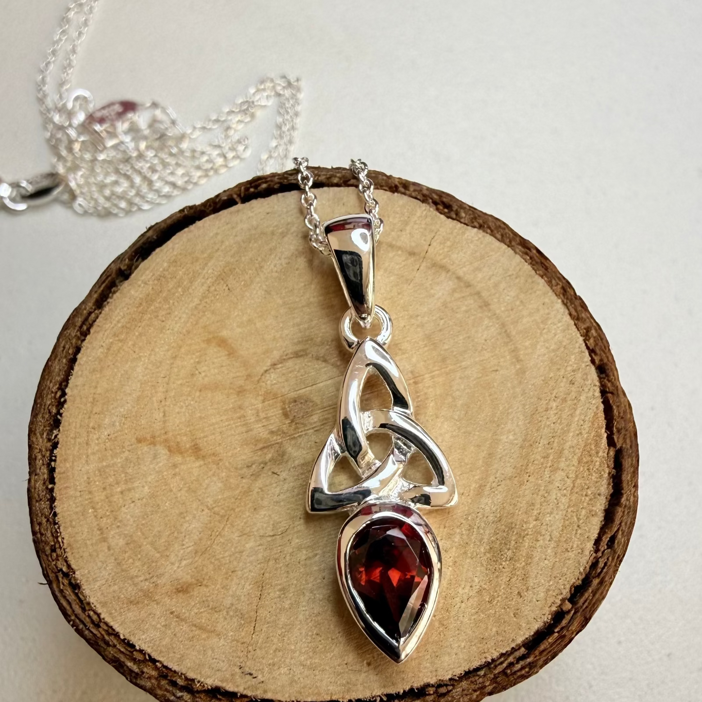celtic knot garnet necklace on wood