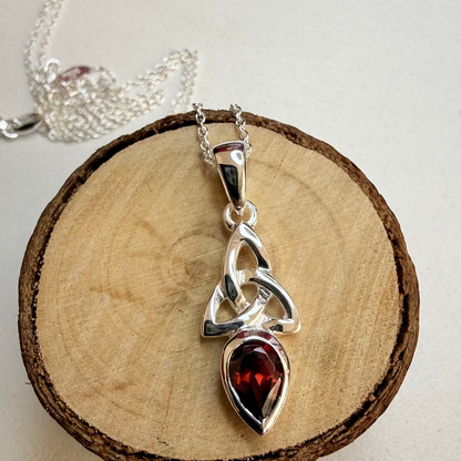 celtic knot garnet necklace on wood