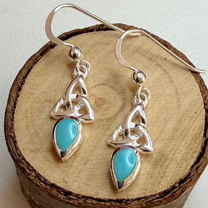 celtic knot turquoise stone earrings on wooden log