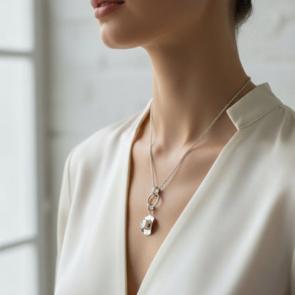 cowboy hat hanging from a charm necklace white background