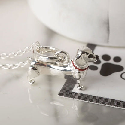 Silver dog-shaped pendant on a chain with a white background