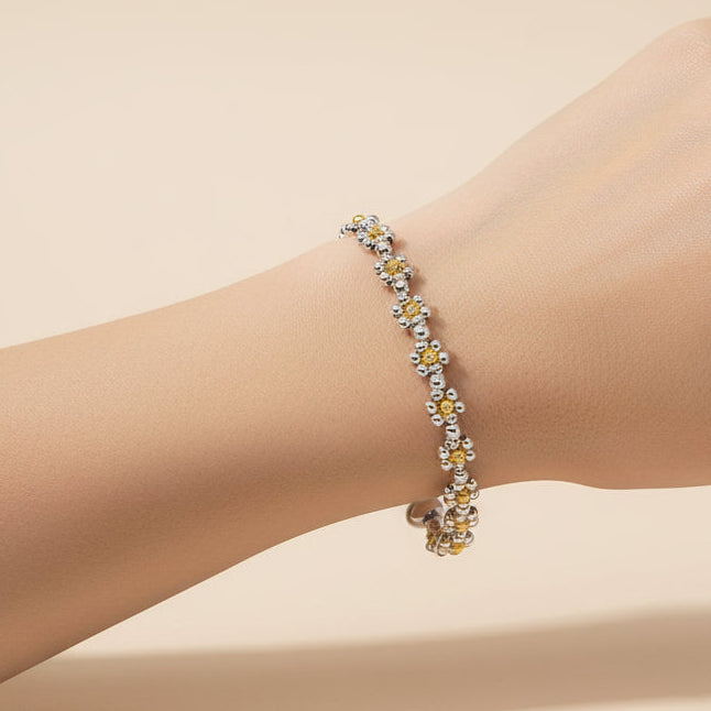 Necklace with yellow and white floral beads on an arm
