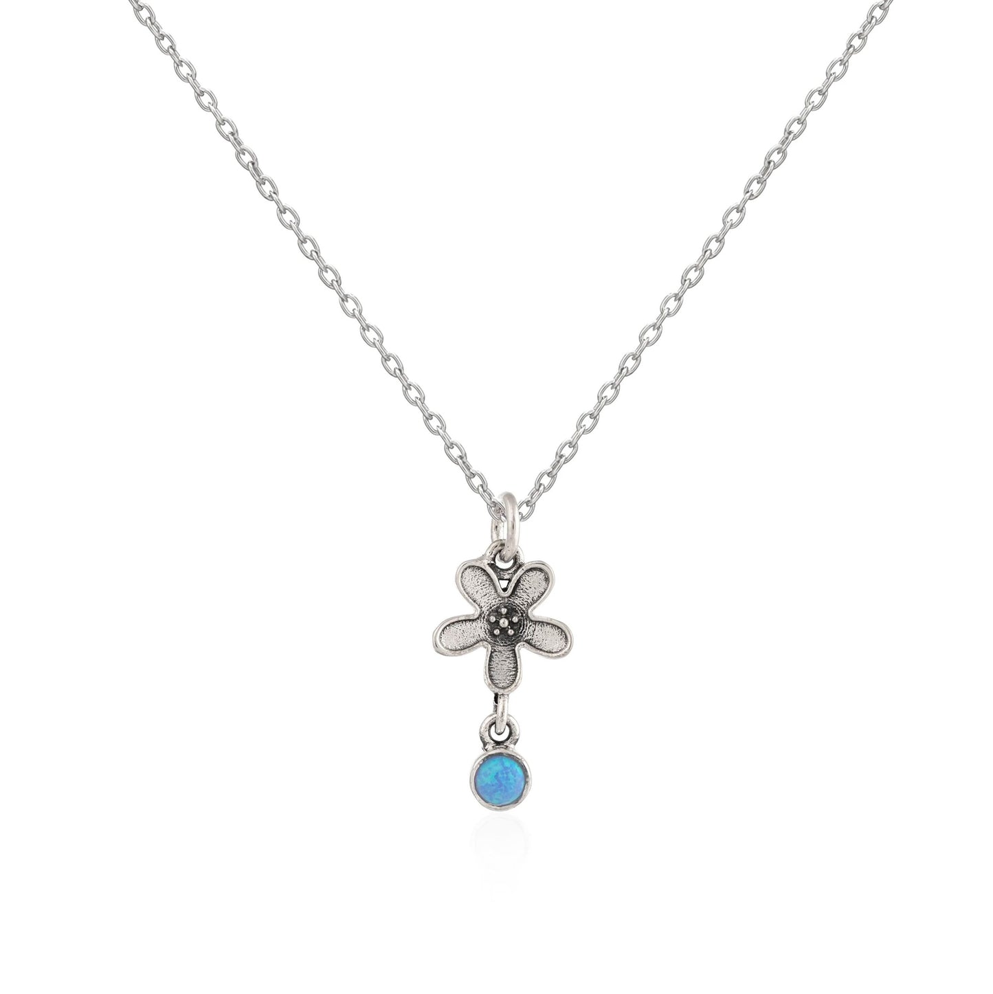 Silver necklace with a flower pendant and blue gemstone on a white background