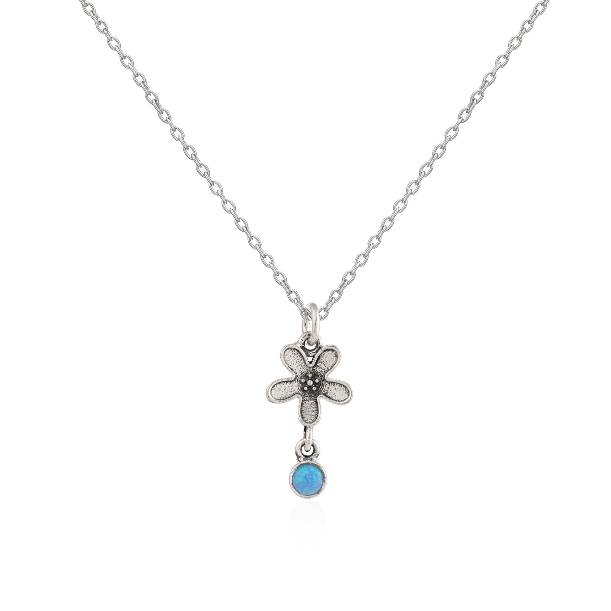 Silver necklace with a flower pendant and blue gemstone on a white background