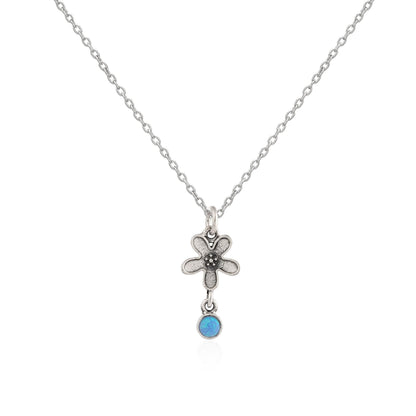 Silver necklace with a flower pendant and blue gemstone on a white background