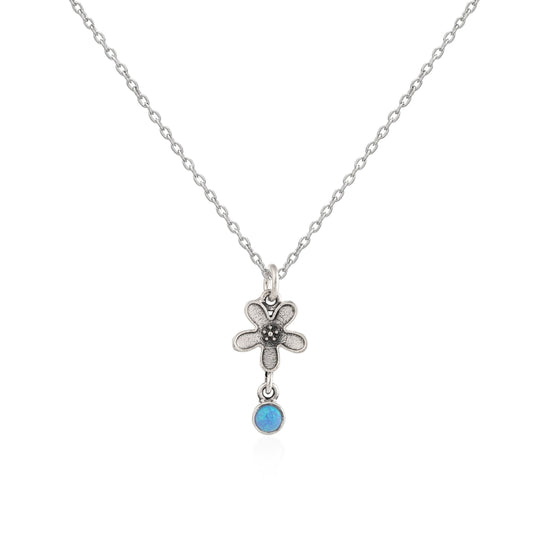 Silver necklace with a flower pendant and blue gemstone on a white background
