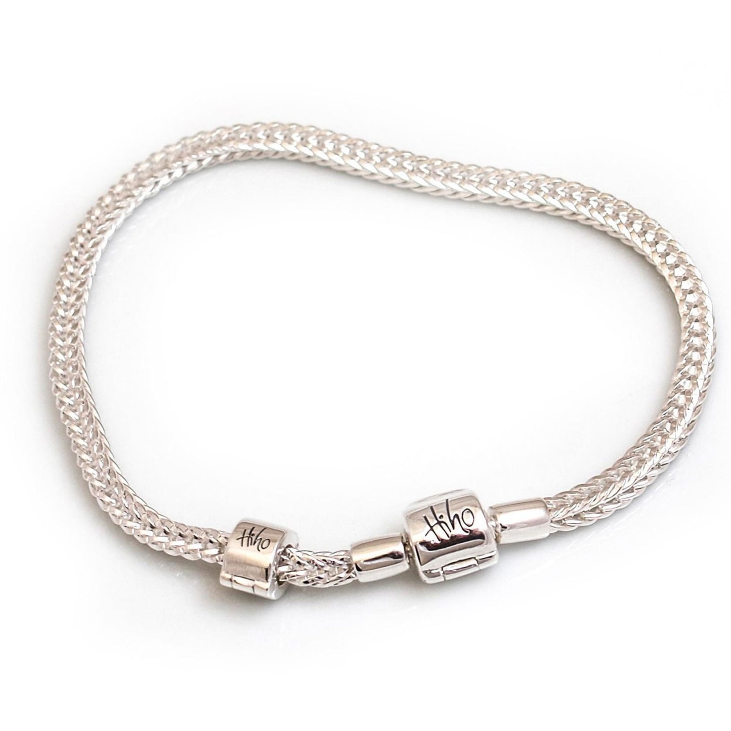 Silver bracelet with two cylindrical beads on a white background