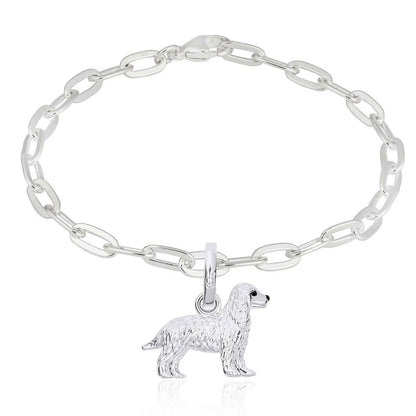 Silver chain bracelet with a dog charm on a white background