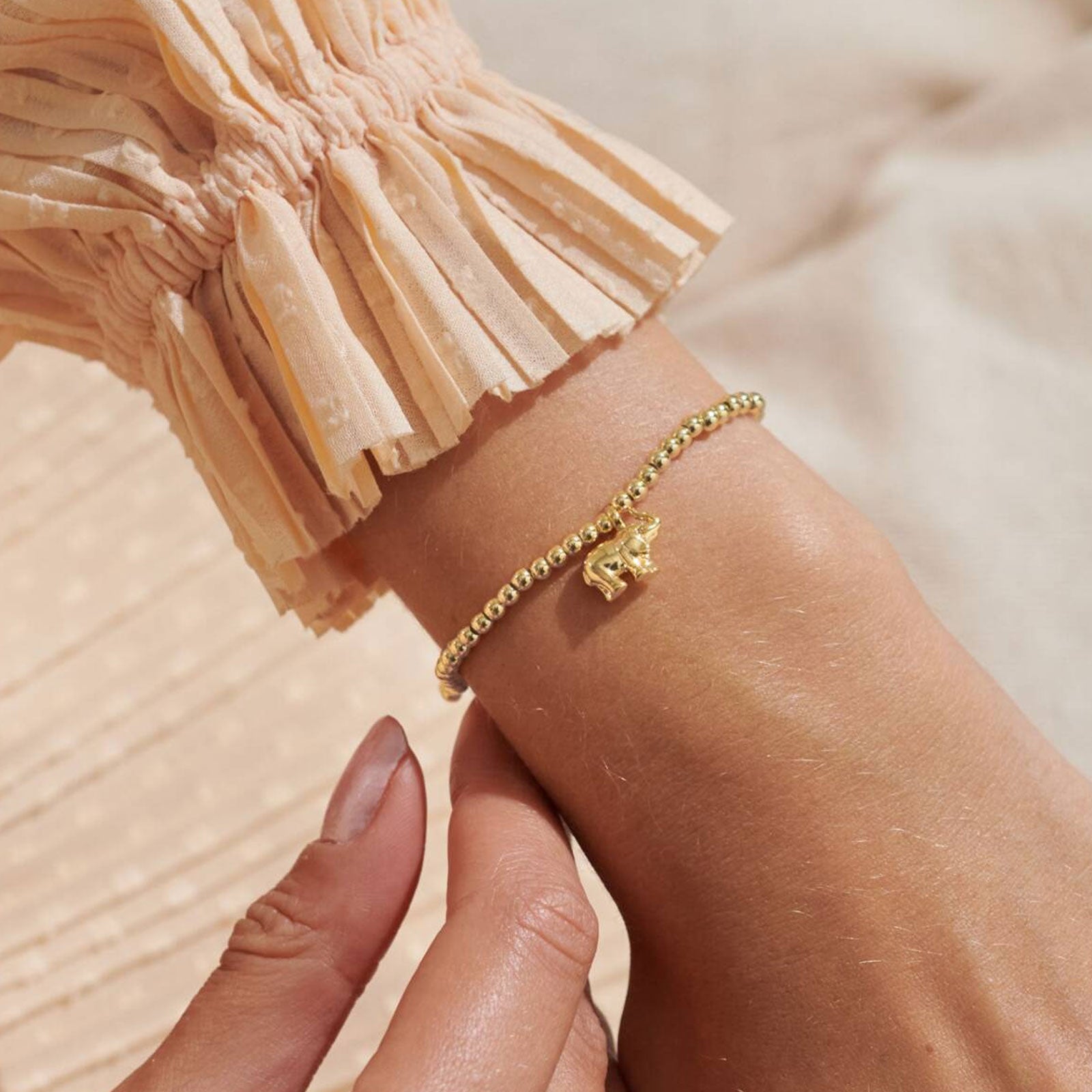 Gold bracelet on a wrist with a blurred background