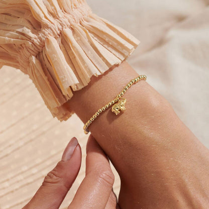 Gold bracelet on a wrist with a blurred background