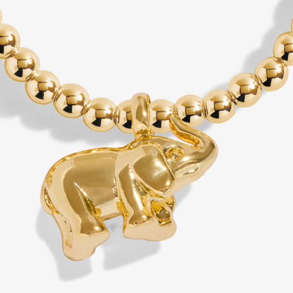 Gold elephant pendant on a gold beaded necklace against a white background