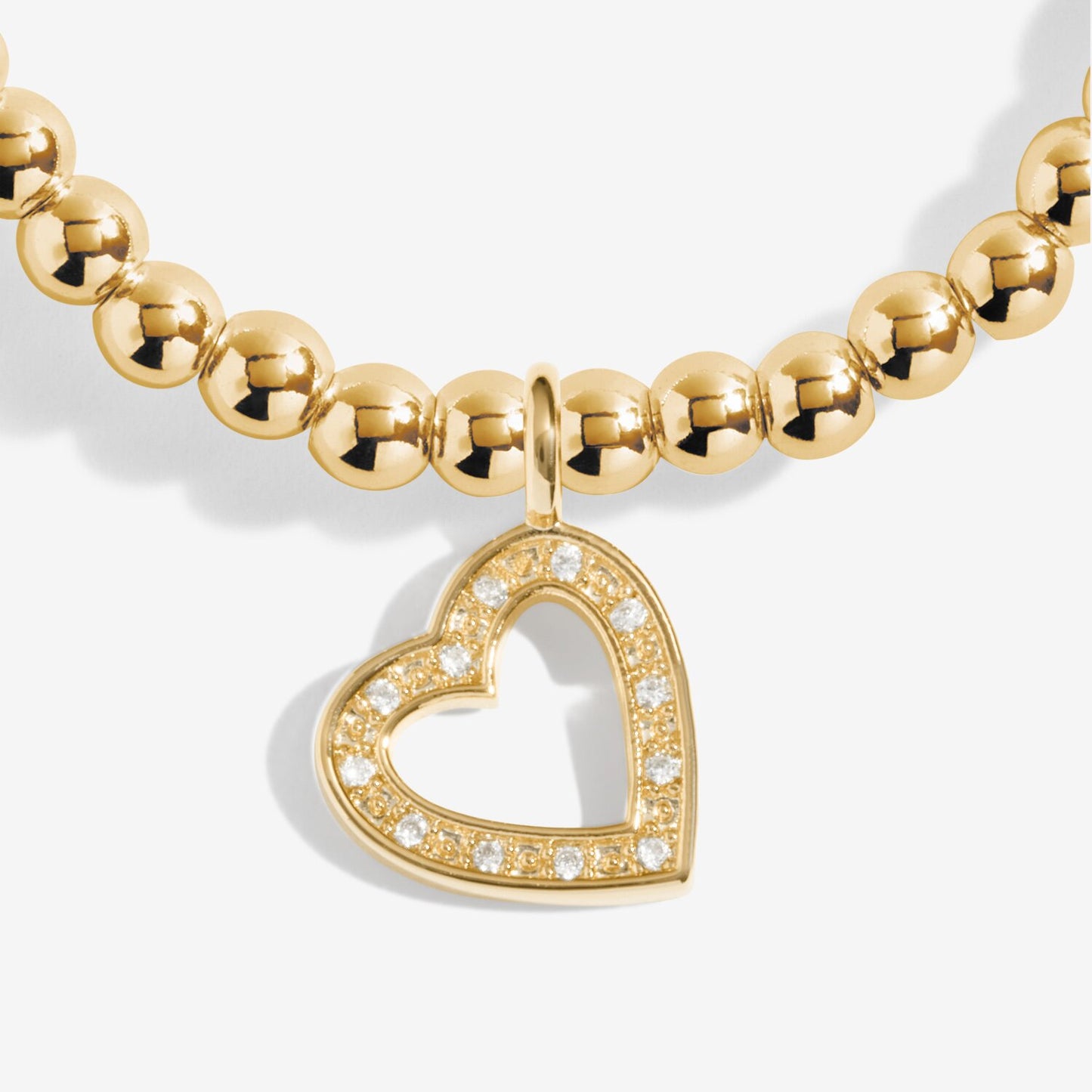 Gold beaded necklace with a heart-shaped pendant on a white background