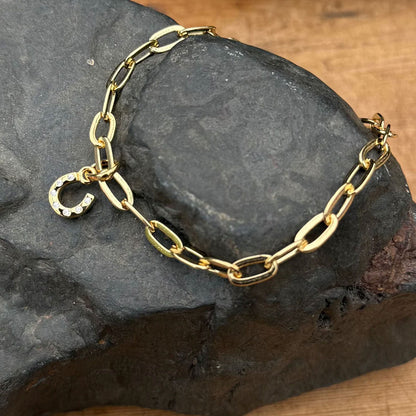 Gold chain bracelet on a dark stone surface