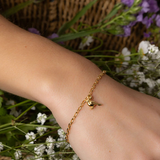 gold robin bracelet on wrist
