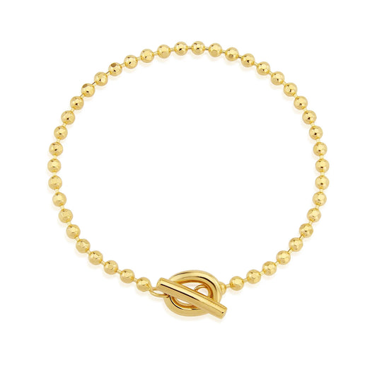 Gold beaded bracelet with a toggle clasp on a white background