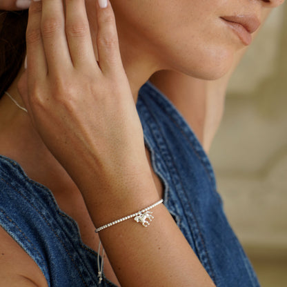 Close-up of a person wearing a delicate horse bracelet on a blurred background