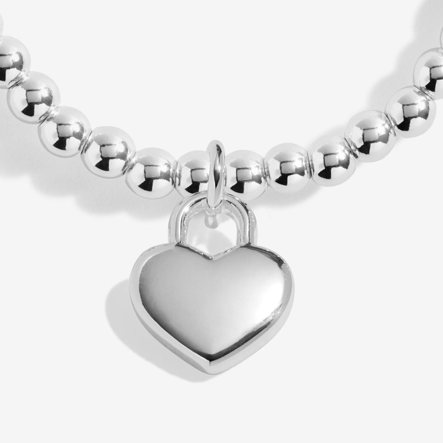 Silver beaded bracelet with a heart-shaped charm on a white background