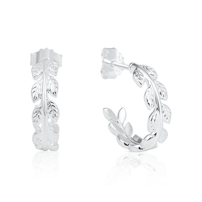A pair of sterling silver huggie hoop earrings featuring a detailed leafy vine design, shown from the front and side on a clean white background with a subtle reflection.