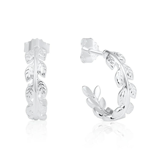 A pair of sterling silver huggie hoop earrings featuring a detailed leafy vine design, shown from the front and side on a clean white background with a subtle reflection.