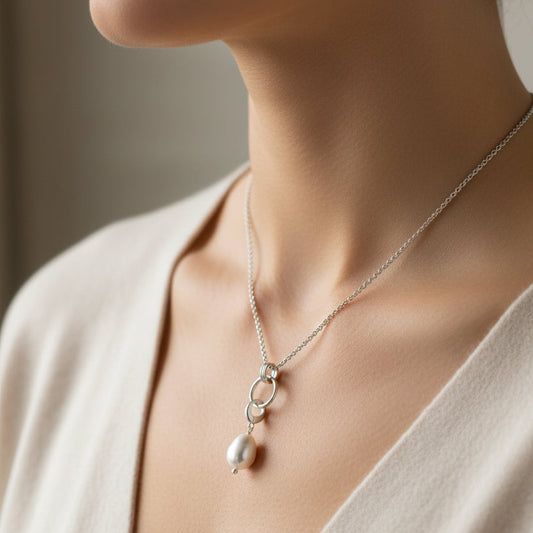 Silver necklace with a pearl pendant on a white background