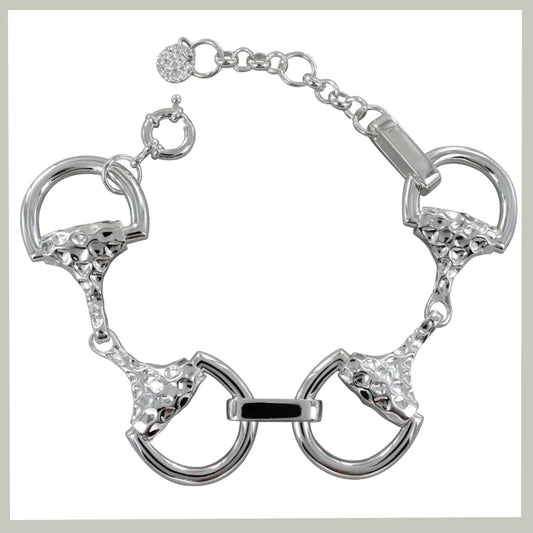 A silver-tone bracelet featuring horsebit-inspired rings with textured details and clear rhinestone accents, shown on a plain white background.
