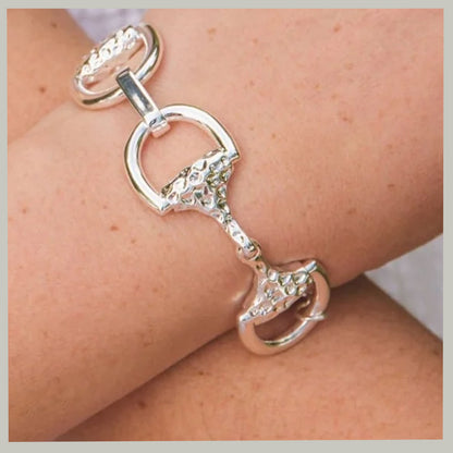 A sterling silver horsebit bracelet with textured details, shown worn on a person's wrist.