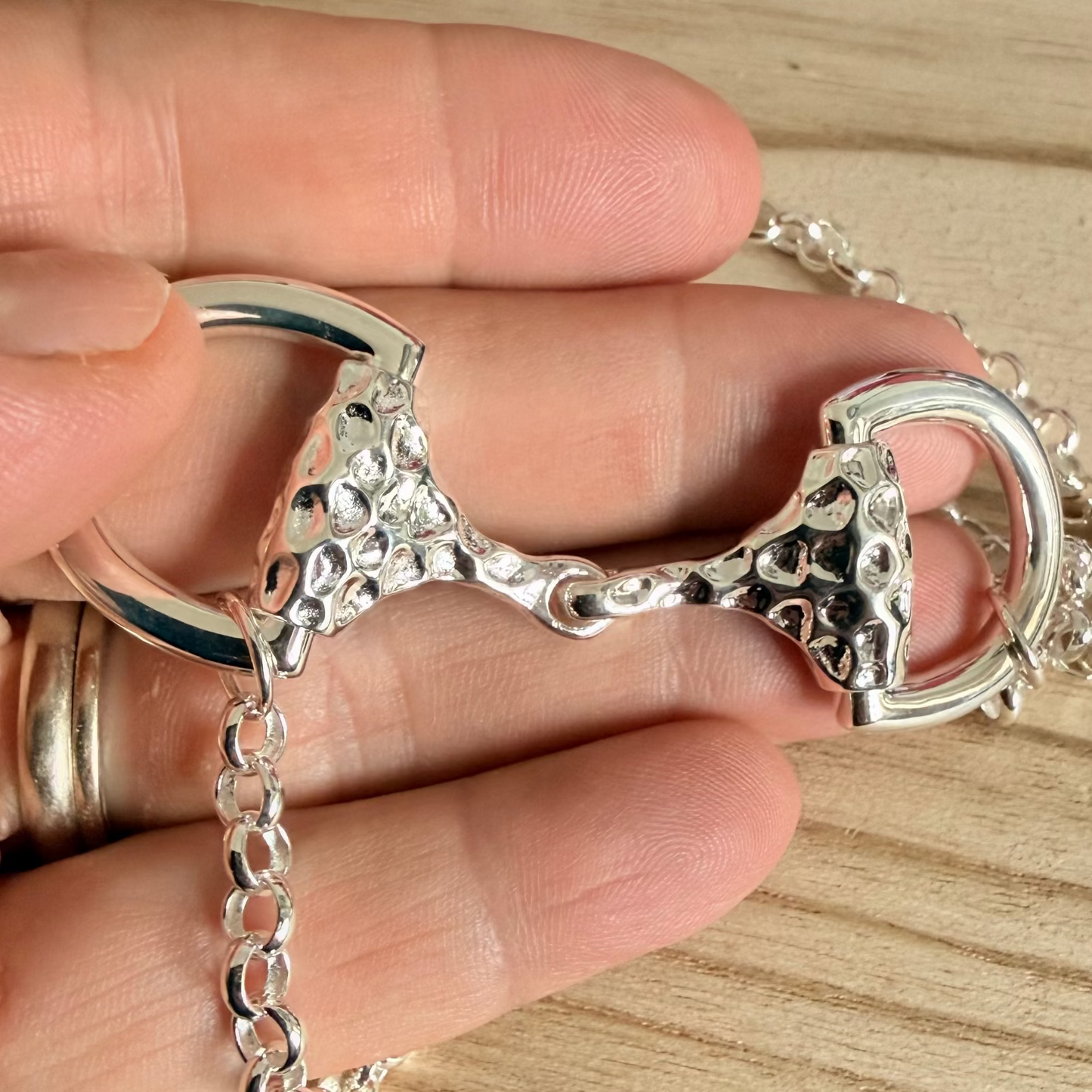 luxuury super size snaffle necklace being held in a hand
