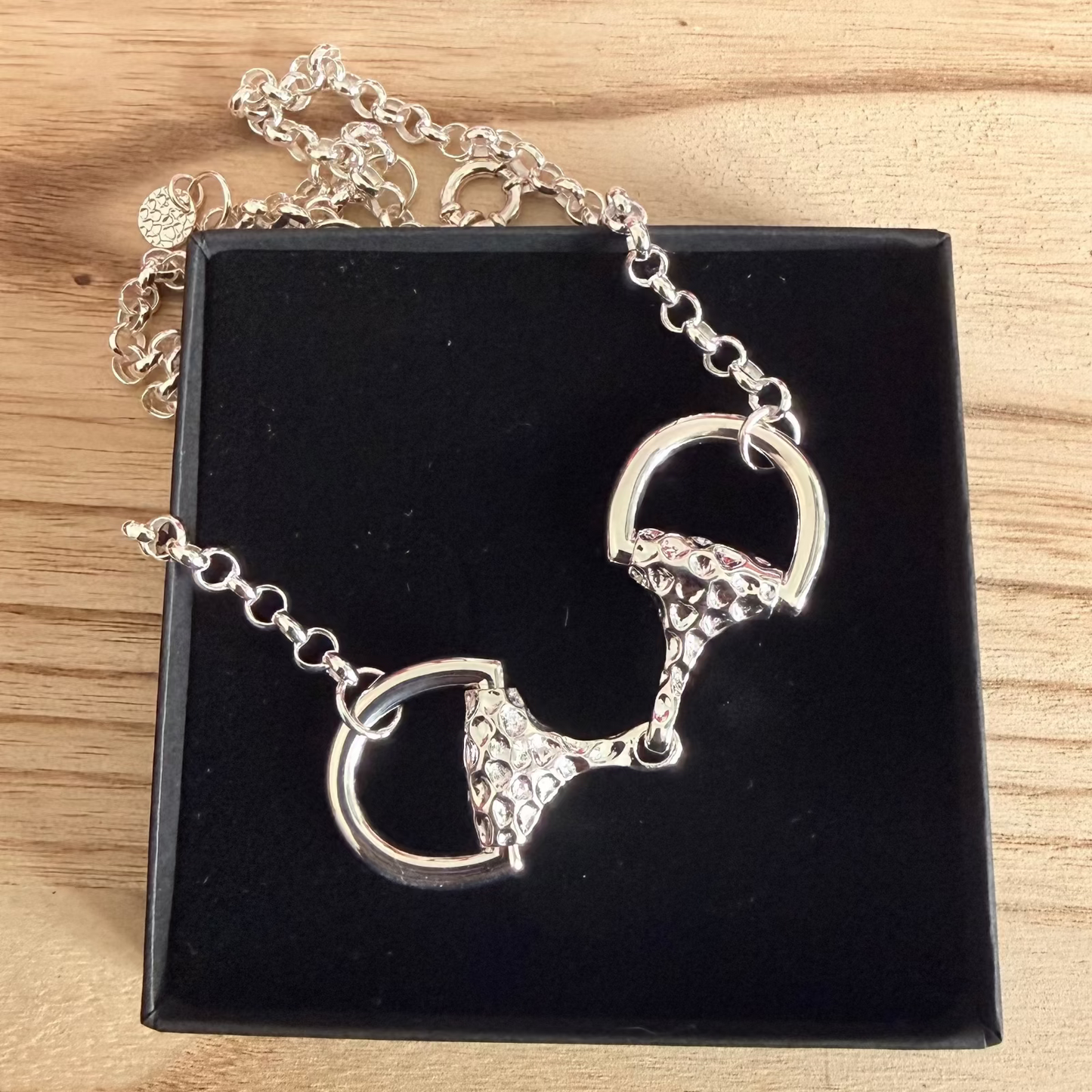statement luxury sparkly snaffle necklace on jewellery box resting on wood