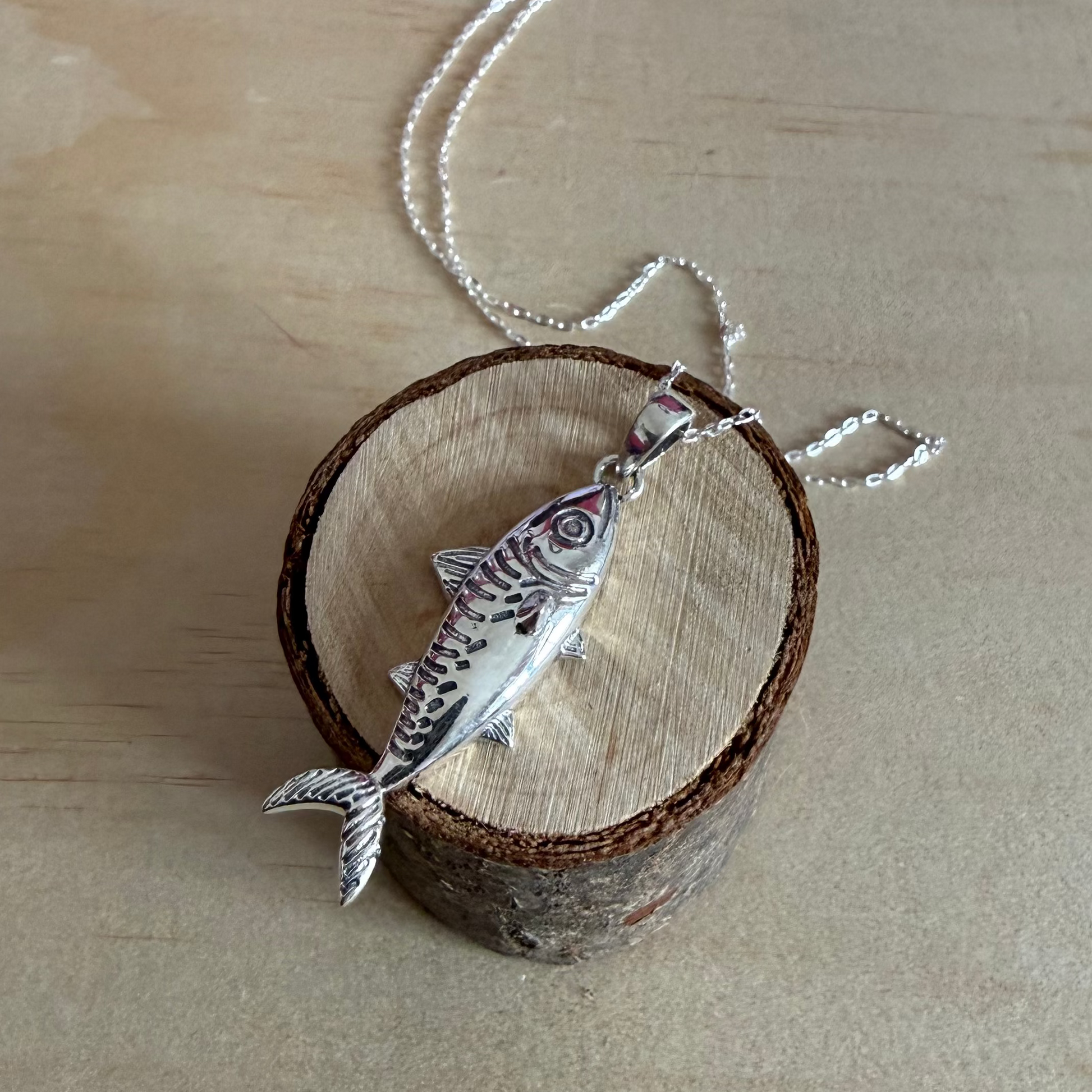 mackerel necklace on piece of wood