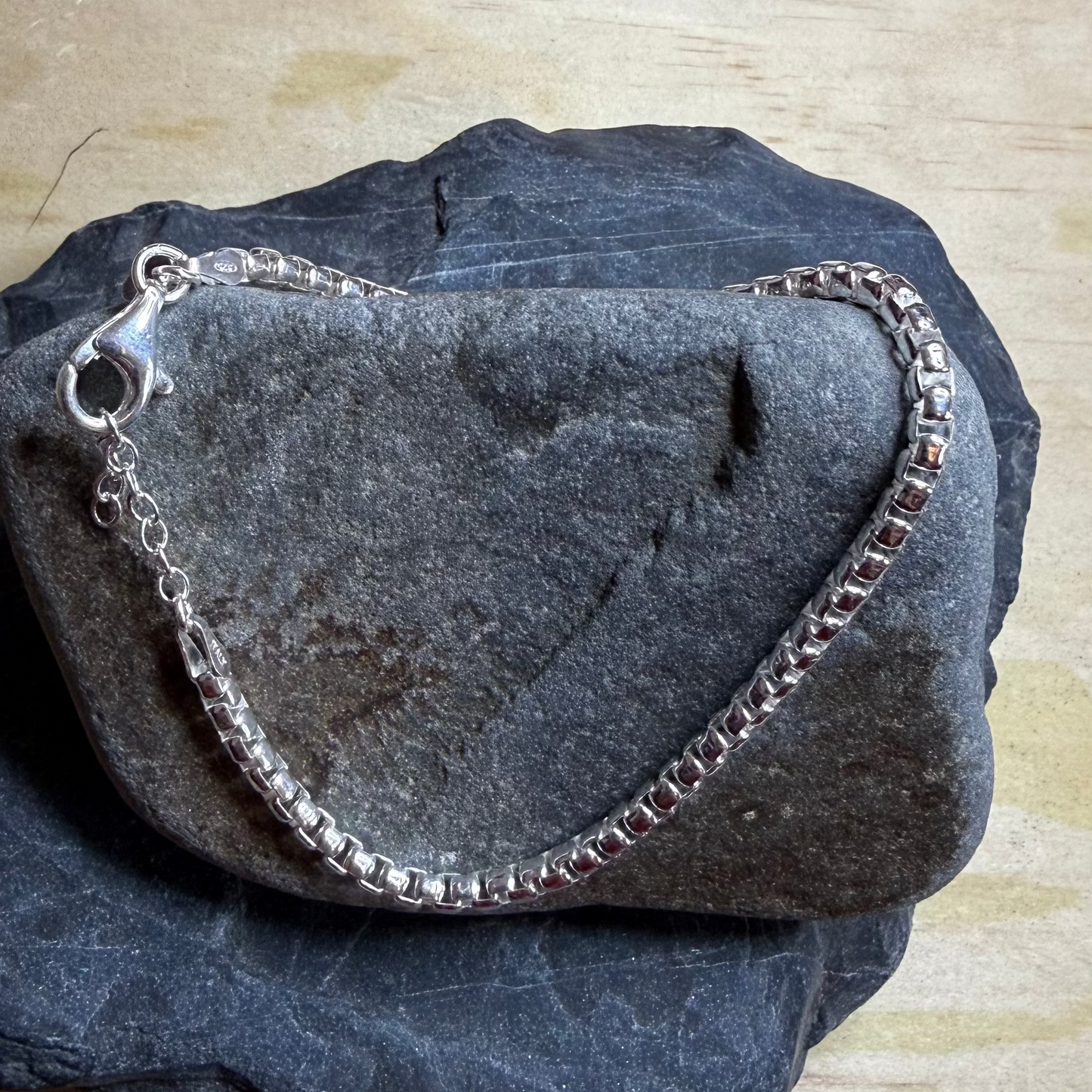 Silver bracelet on a dark stone surface