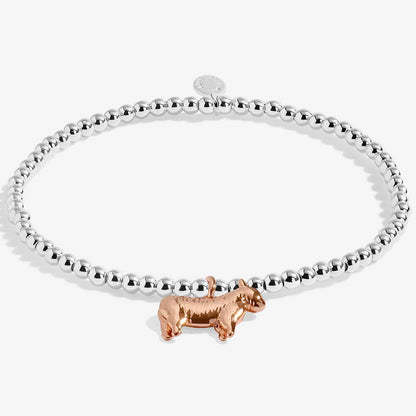 A silver beaded bracelet with a small rose gold dachshund charm, displayed on a clean white background.